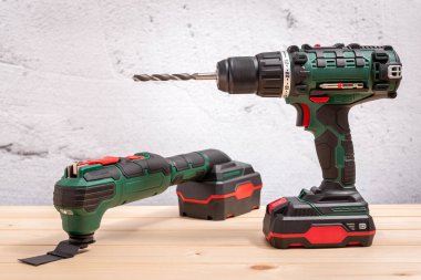 Matkap ucuyla tornavida matkabı ve ahşap bir masada çok fonksiyonlu titreşim cihazı. Seçici odak.