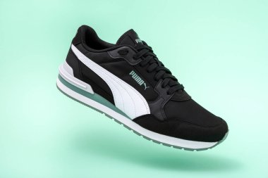 Obrenovac, Sırbistan - 10 Temmuz 2025: Açık yeşil arka planda şık siyah Puma ayakkabısı.