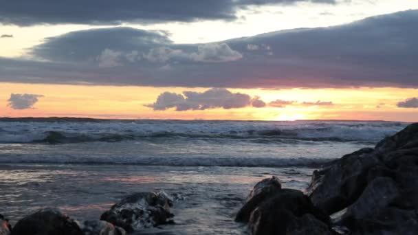 ウールアコムビーチ デヴォン 英国で岩に打ち寄せる波の夕日を眺めます — ストック動画