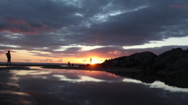 英国デヴォン州の日没時にウールアコムのビーチで匿名の人々 — ストック動画