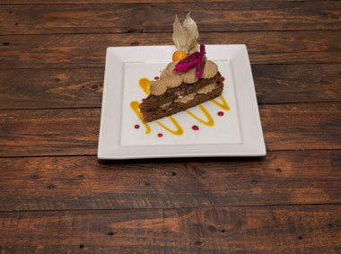 Slice of vegan raw cake with dragon fruit and goldenberry