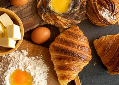 Taze pişmiş İsveç tarçınlı çörek, kruvasan ve kremalı spandauer, tereyağı, yumurta ve un.