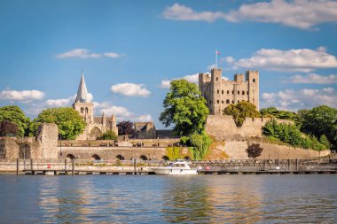 View of historical Rochester across river Medway in sunny afternoon. clipart