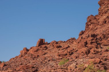 Namibya Çölü, binlerce yıldır doğal süreçler tarafından şekillendirilen dağınık kahverengi taşlara ve engebeli kaya oluşumlarına ev sahipliği yapar. Bu özellikler etrafındaki altın kumlarla keskin bir tezat oluşturarak kendine özgü bir çöl manzarası yaratır.