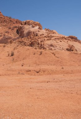 Namibya Çölü, binlerce yıldır doğal süreçler tarafından şekillendirilen dağınık kahverengi taşlara ve engebeli kaya oluşumlarına ev sahipliği yapar. Bu özellikler etrafındaki altın kumlarla keskin bir tezat oluşturarak kendine özgü bir çöl manzarası yaratır.