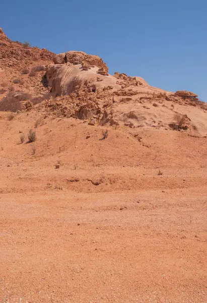 Namibya Çölü, binlerce yıldır doğal süreçler tarafından şekillendirilen dağınık kahverengi taşlara ve engebeli kaya oluşumlarına ev sahipliği yapar. Bu özellikler etrafındaki altın kumlarla keskin bir tezat oluşturarak kendine özgü bir çöl manzarası yaratır.