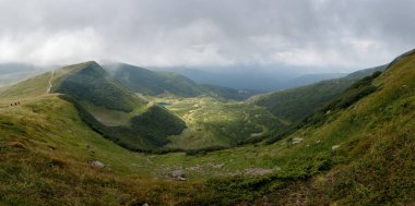 Dağ sırasının panoramik manzarası. Muhteşem manzaralı dağlarda bir tatil. Dağların tepesindeki vadi.