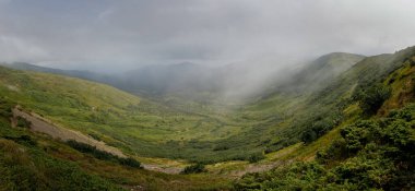 Dağ sırasının panoramik manzarası. Muhteşem manzaralı dağlarda bir tatil. Dağların tepesindeki vadi.