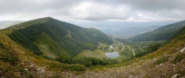 Dağ sırasının panoramik manzarası. Muhteşem manzaralı dağlarda bir tatil. Yüksek dağların arasında göl.