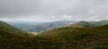 Dağ sırasının panoramik manzarası. Muhteşem manzaralı dağlarda bir tatil. Dağların tepesindeki vadi.