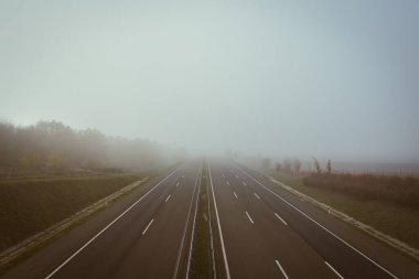 Sisli bir kış sabahı fotokopi alanı olan boş bir otoyol.