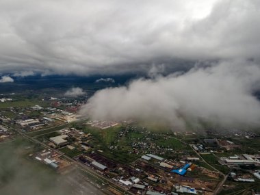 Şehrin üzerinde bulutlar var. Yukarıdan bak. Bir uçaktan şehir manzarası. Kuş bakışı bir bakış açısından. Şehrin üzerinde uçuyor. Şehir manzarası. Bulutları inceliyorum. Hava ve atmosfer. Şehir manzarası havası.