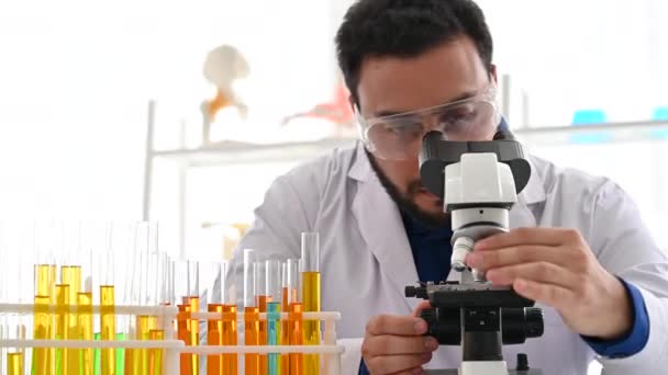 研究室で顕微鏡を見る4K科学者 — ストック動画