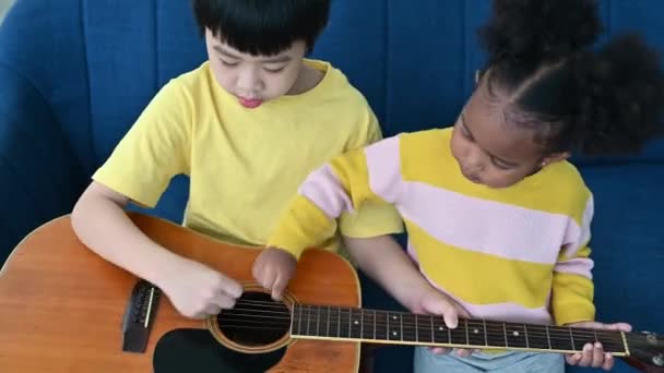 Африканская Девочка Мальчик Учатся Играть Гитаре Сидя Дома Диване — стоковое видео