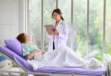 Asyalı doktor hastanede hastayla konuşuyor.