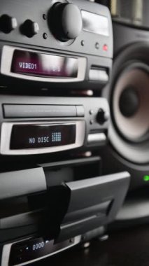 Bir adamın dikey görüntüsü 4K Klasik stereo teyp teybini takıp oynatır