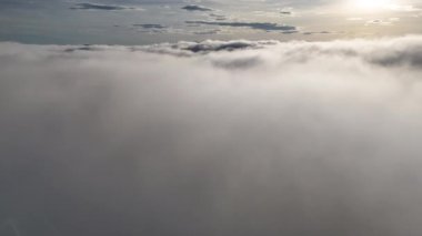 Sabah güneşinde güzel bulutların üzerinde 4K hava manzarası