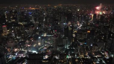 Yeni yılı kutlamak için havai fişeklerle Bangkok gökdelen manzaralı 4K