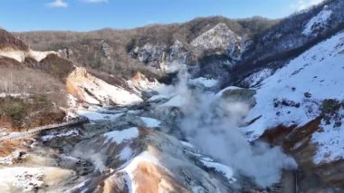 Japonya 'nın Hokkaido kentindeki Noboribetsu şehrindeki Jigokudani Cehennem Vadisi' nin 4K hava görüntüsü