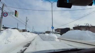 4K Winter POV hızla yükselen kar yığınlarıyla çevrili küçük bir kasabadan geçiyor.