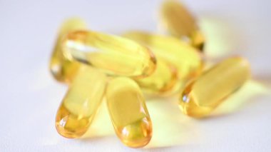 Balık yağı kapsüllerinin yavaş çekim düşüşü masaya