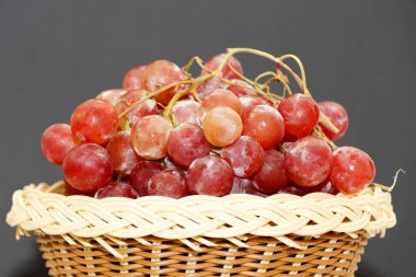 Tahta sepetteki Lezzetli Kırmızı Üzüm 'ün yakın çekimi. Karanlık Arkaplan