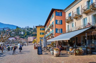 ASKONA, SWitzERLAND - 28 Mart 2022: The Piazza Giuseppe Motta, 28 Mart 'ta Ascona' da bulunan birçok açık hava restoranı, yürüyüş sokağı ve göl kenarındaki ana turizm merkezlerinden biridir.