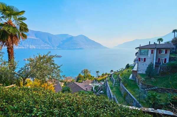 stock image The mountain slope with terrace gardens, old houses and villas against Lake Maggiore and hazy mountains, Ronco sopra Ascona, Ticino, Switzerland