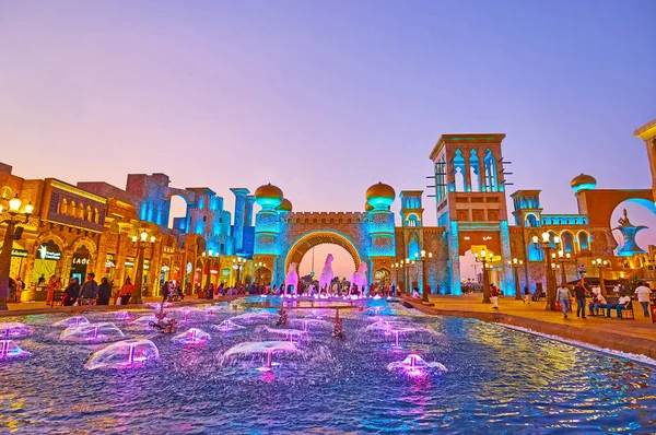 stock image DUBAI, UAE - MARCH 6, 2020: The lighting dancing fountains in Culture Square of Global Village Dubai and Cultural Gate with horseshoe arch, barjeel towers (windcatchers), on March 6 in Dubai