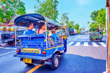BANGKOK, THAILAND - 23 Nisan 2019: Çağdaş ilçelerin geniş caddeleri boyunca hızlı tuk-tuk taksisi, 23 Nisan 'da Bangkok, Tayland