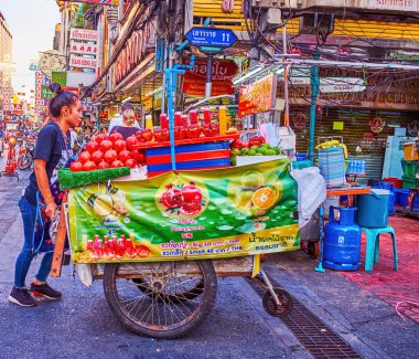 BANGKOK, THAILAND - 23 Nisan 2019: Çin Mahallesi 'nde, 23 Nisan' da Tayland 'ın Bangkok kentinde, Çin Mahallesi' nde, büyük araba dolusu meyve satan genç kız tüccar