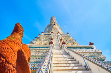 Ana beyaz Wat Arun kompleksinin ön planda taştan mitolojik yaratıkla Bangkok, Tayland