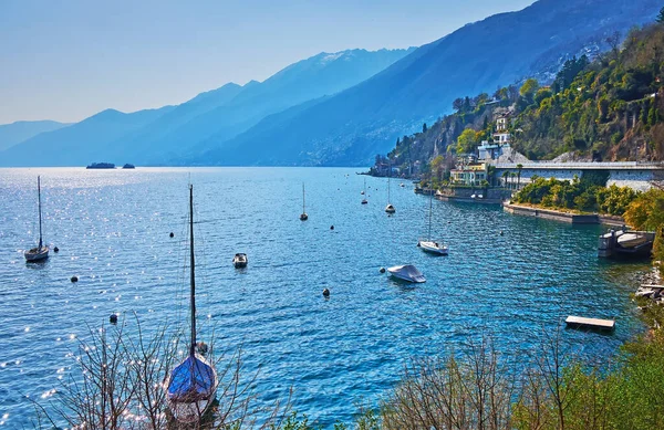 美丽的游艇停泊在瑞士阿斯科纳的马焦雷湖蓝色的水面上 周围环绕着朦胧的群山 — 图库照片