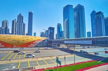 DUBAI, BAE - 2 Mart 2020 'de Dubai' deki Business Bay metro istasyonu, hava yürüyüşü ve modern cam gökdelenlerin önündeki kalabalık Şeyh Zayed yolu