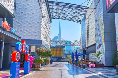 DUBAI, BAE - 6 Mart 2020: Burj Halife 'nin silueti arka planda, 6 Mart' ta Dubai 'de, Şehir Yürüyüşü alışveriş merkezinin yaya sokağı