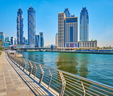 DUBAI, BAE - 6 Mart 2020: Dubai Su Kanalı Dubai Şelale Köprüsü 'nün arkasındaki Al Habtoor City binaları modern cam Marriot Marquis ile 6 Mart' ta Dubai Su Kanalı