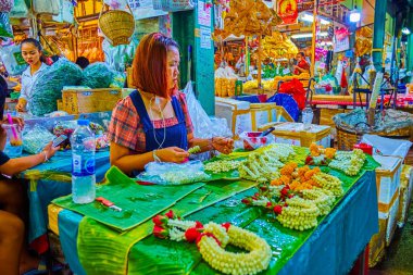 BANGKOK, THAILAND - 23 Nisan 2019: Satıcı, 23 Nisan 'da Bangkok' ta Pak Khlong Talat Çiçek Pazarı 'nda çiçek kompozisyonlarında çiçek kolonları yapıyor.