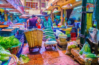 BANGKOK, THAILAND - 23 Nisan 2019: Wang Burapha Phirom pazarında 23 Nisan 'da büyük sepet ve paketlerle tarımsal ürünler taşıyan hamallar
