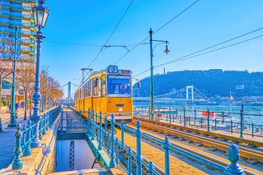 BUDAPEST, HUNGARY - 2 Mart 2022 'de Budapeşte' de popüler turistik bölge olan Tuna seti boyunca geriye dönük sarı tramvay gezileri