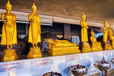 Bangkok, Tayland 'da bulunan San Lak Mueang (Şehir Sütun Tapınağı), yanan gaz lambalarıyla küçük sunakta bulunan Lord Buddha' nın altın heykelleri.