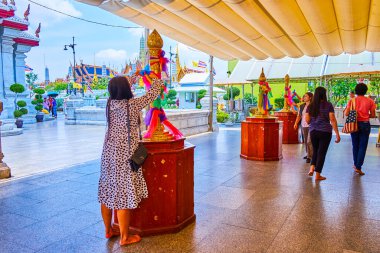 BANGKOK, THAILAND - 23 Nisan 2019: Takipçi, 23 Nisan 'da Bangkok, Tayland' da San Lak Mueang türbesindeki sütuna kurdele bağlama ayini yapıyor.