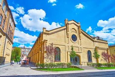 Bahçe yatakları ve yayalar, eski Arsenal Fabrikası 'nın antika tuğla binaları arasında, bugünlerde ofis ve gıda katı olarak hizmet veren Kyiv, Ukrayna