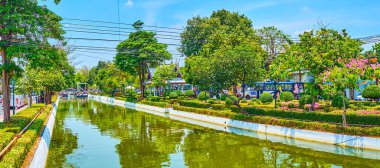 BANGKOK, THAILAND - 23 Nisan 2019: Çiçek yatakları ve Rop Krung Kanalı ile dar yemyeşil park panoraması, 23 Nisan 'da Bangkok, Tayland