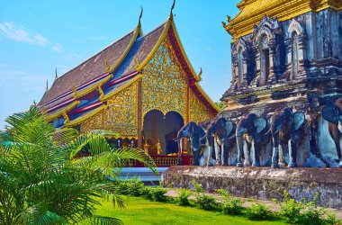 Fil Chedi 'nin heykelleri ve güzel çiçek desenleri ve ayna mozaikleriyle süslenmiş Viharn' ın cephesi, Wat Chiang Man tapınağı, Chiang Mai, Tayland