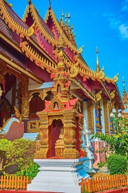 The richly decorated tiny Ku shrine of Wat Saen Muang Ma temple in front of the viharn, Chiang Mai, Thailand