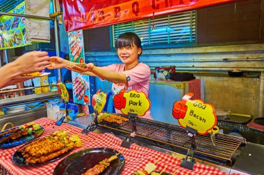 CHIANG MAI, THAILAND - MAY 3, 2019: The street food stall on Night Market with BBQ pork and chicken on skewers, on May 3 in Chiang Mai