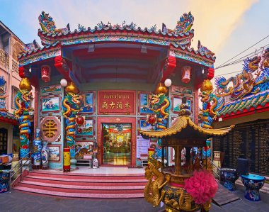 The sculptured facade of Pung Thao Kong Shrine with sweeping roof, dragon pillars, colored paintings, Chiang Mai, Thailand
