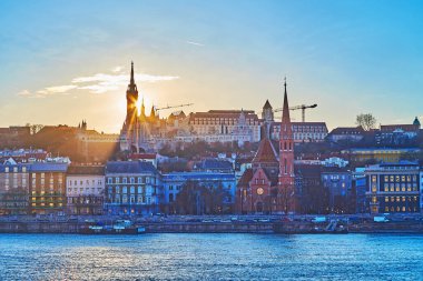 Silhouette of Fisherman's Bastion behind Danube River at golden sunset, Budapest, Hungary