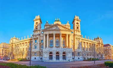 Panorama of sculptured facade of Ethnographic Museum, decorated with stone and bronze statues, located on Lajos Kossuth Square, Budapest, Hungary