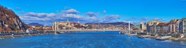Panorama of bright blue Danube River, reflecting the sunny sky and beautiful white Elisabeth Bridge against the Buda Castle, Budapest, Hungary